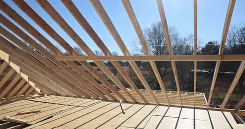 Home Construction with Lumber Framework and Bright Sunlight
