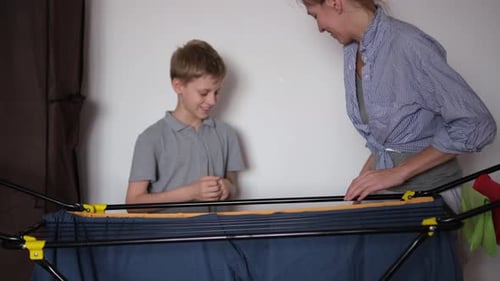 Mom and Teen Putting Clothing on Drying Rack