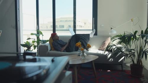Young Adult Working on Laptop While Relaxing at Home