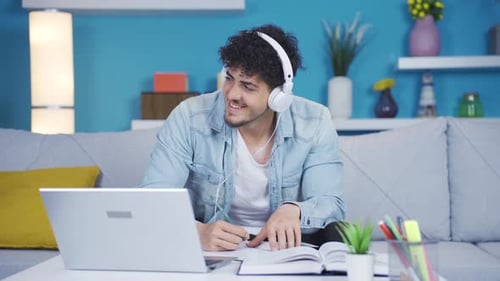 Young Adult Studying with Laptop and Headphones Indoors
