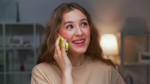 Smiling Young Woman Talking on Smartphone at Home