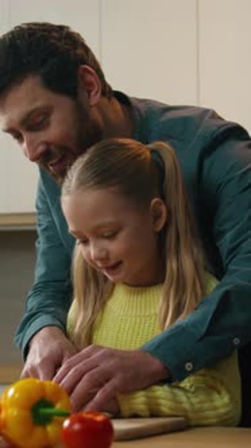 Father and Child Cutting Vegetables in Bright Kitchen