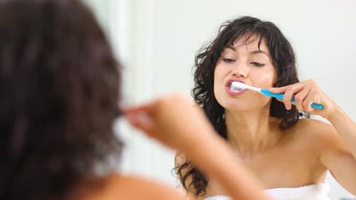 Woman Brushing Teeth in Bright Bathroom Close Up
