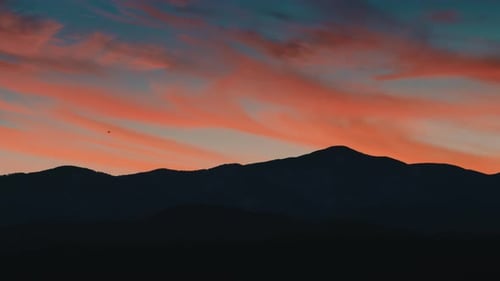 Majestic Sunset over Mountainous Landscape with Vibrant Clouds