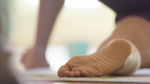 Pied d'une fille pratiquant une pose de yoga sur le tapis. Gros plan