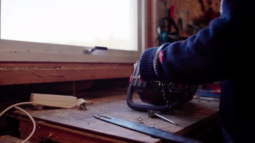 The Man is Maintaining His Chainsaw for Cutting Trees Into Firewood in Indre Fosen, Trondelag County