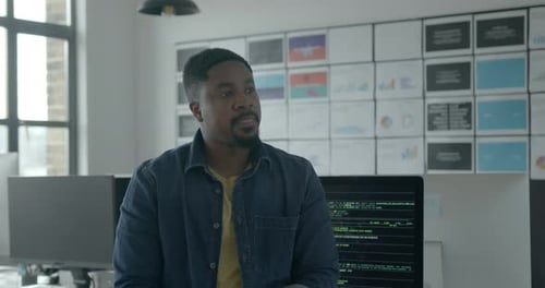 Porträt eines Geschäftsmannes, der im Creative Office in die Kamera schaut