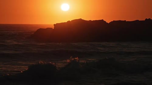 Ocean waves moving in slow motion during colorful sunset