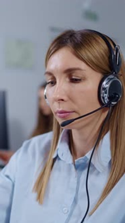 Focused Female Call Center Operator Wearing Headset Assisting Customers in Modern Office Support