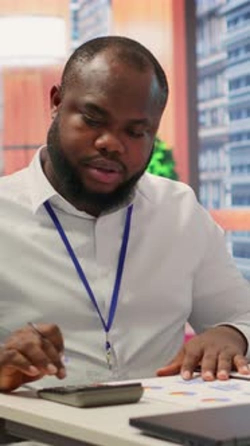 Man Discussing Finances with Calculator and Graphs