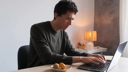 Young Adult Working on Laptop at Home