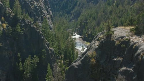 A Bright Turquoise Mountain Stream Cascades Through a Steep Narrow Canyon In