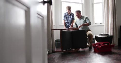 Father teaching Son how to fix a chair