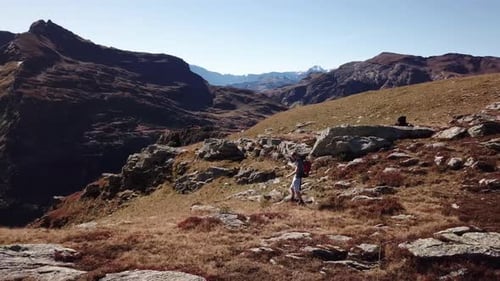 Vue aérienne en parallaxe d'un randonneur masculin adulte marchant à travers une montagne rocheuse en Suisse