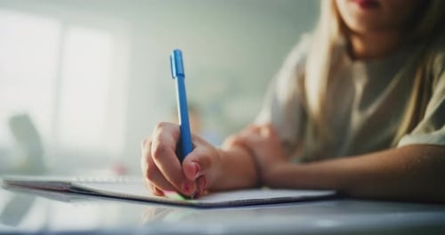 Close Up Shot of Young Girl Writing Exam Doing Task or Drawing in Notebook