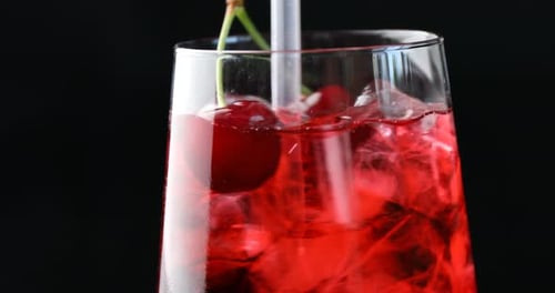Refreshing Red Cocktail with Ice and Fresh Cherries