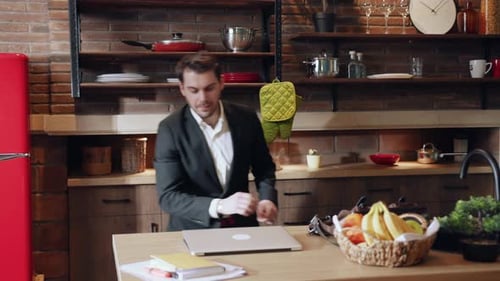 Successful Businessman Celebrates Good News in Kitchen