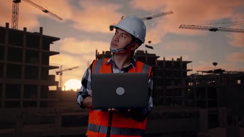 Asiatischer männlicher Ingenieur arbeitet auf einer Baustelle an einem Laptop