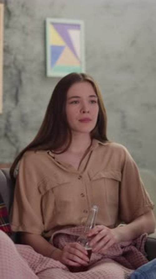 Young Women Relaxing Together on Couch Indoors