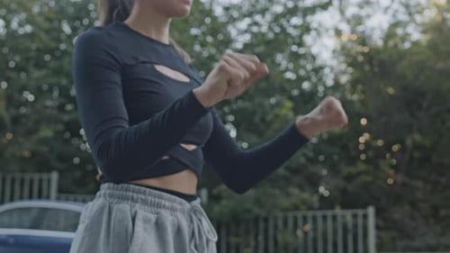 Woman Stretching Arms Outside in Urban Setting