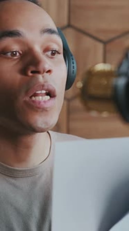 Young Man Recording Voiceover in a Cozy Studio with Wooden Accents