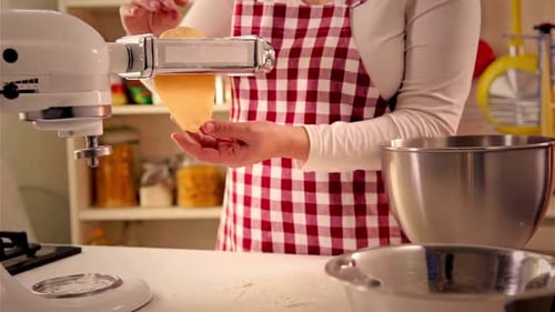 Woman Making Pasta with Machine in Kitchen