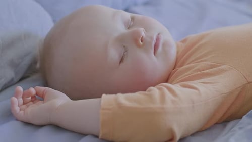 Infant Sleeping Peacefully on a Blue Bed