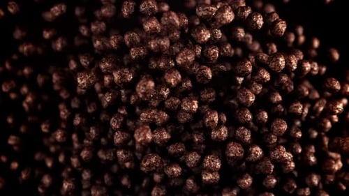 Chocolate Cereal Puffs Floating on Black Background