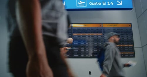 Airport Terminal Woman with Luggage and Ticket Checks Her Flight on Digital Departure Board