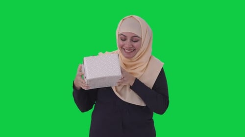 Happy Muslim woman receiving a gift Green screen