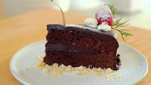 Man Hand Taking a Bite of Moist Delicious Chocolate Cake with a Spoon