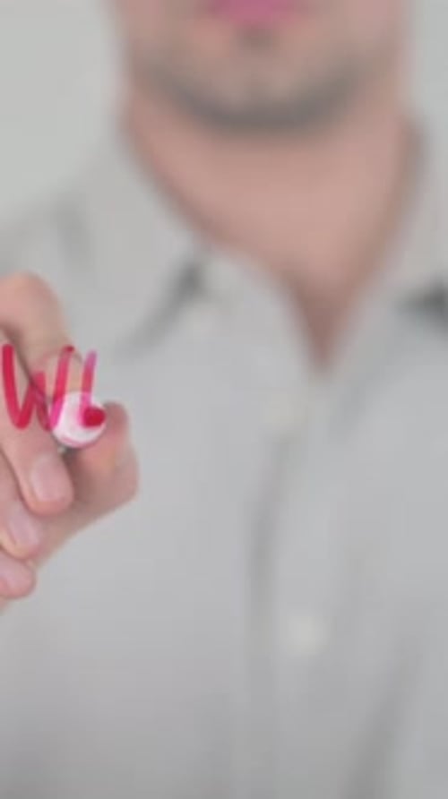 Man Writing Website with Marker on Transparent Glass