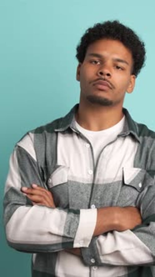 Disagreeing Young Man Shaking Head in Blue Studio