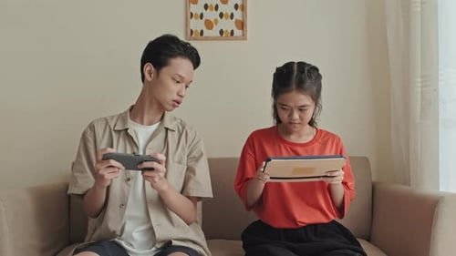 Teens Play Games Together Indoors on Devices