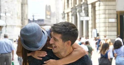 A young handsome guy and a girl in a hat, having fun, smiling happily, in Milan. The concept: tour