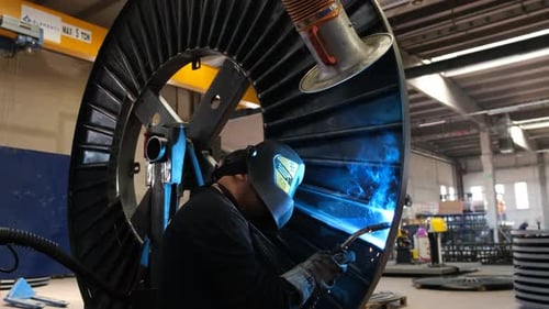 Industriefabrik Ein Mann mit Helm arbeitet beim Schweißen