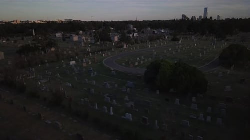 Aerial descending shot overhead a large graveyard during sunset