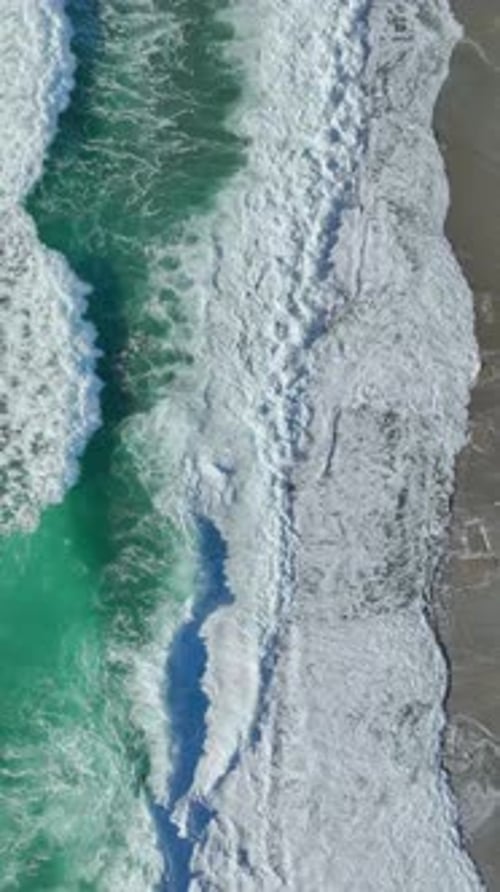 Aerial View of Ocean Waves Crashing on Beach