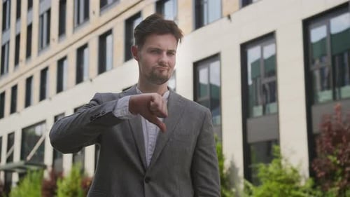 Businessman Showing Disapproval with Thumbs Down Gesture