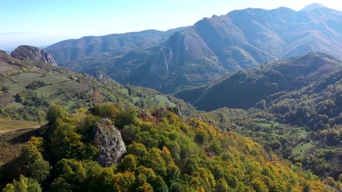 Flying over misty autumn mountains and colorful forest aerial by drone