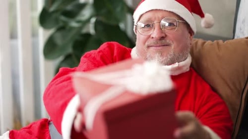 Friendly Santa Claus Holding Christmas Gift Close Up