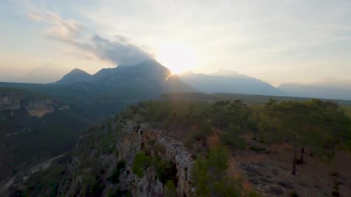 Vue en angle élevé des forêts au sommet des falaises et d'une montagne avec un nuage