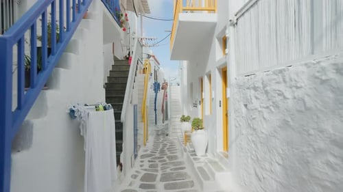 Houses with painted railings along a narrow street in Mykonos, Greece