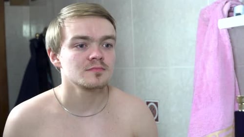 Young Man Applying Perfume on His Neck in Bathroom