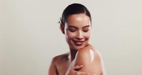 Woman Applies Cream to Shoulder in Close-Up
