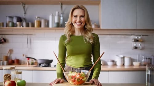 Smiling Woman with Salad in Bright Kitchen