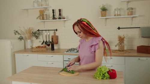 Woman Cutting Vegetables in a Bright Kitchen