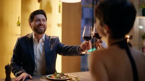 Amoureux romantiques qui tintent des verres dans un appartement, gros plan, réunion de couple heureuse