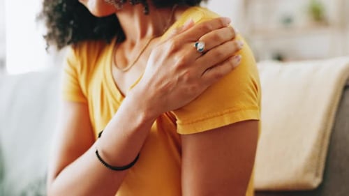 Woman Rubbing Shoulder in Living Room Close Up