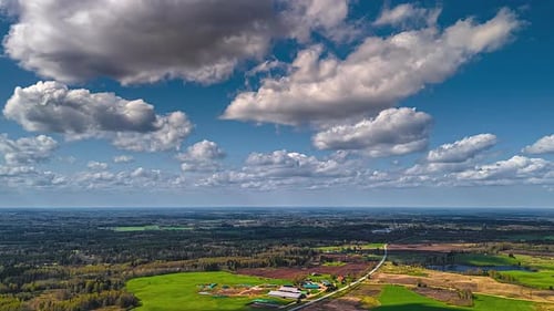 Countryside village landscape with clouds passing overhead - high-altitude drone timelapse
